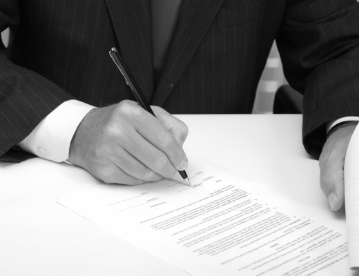 Businessman with black pen signing contract.
